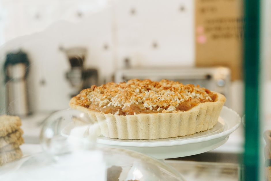 An apple crumble tart on a cake stand